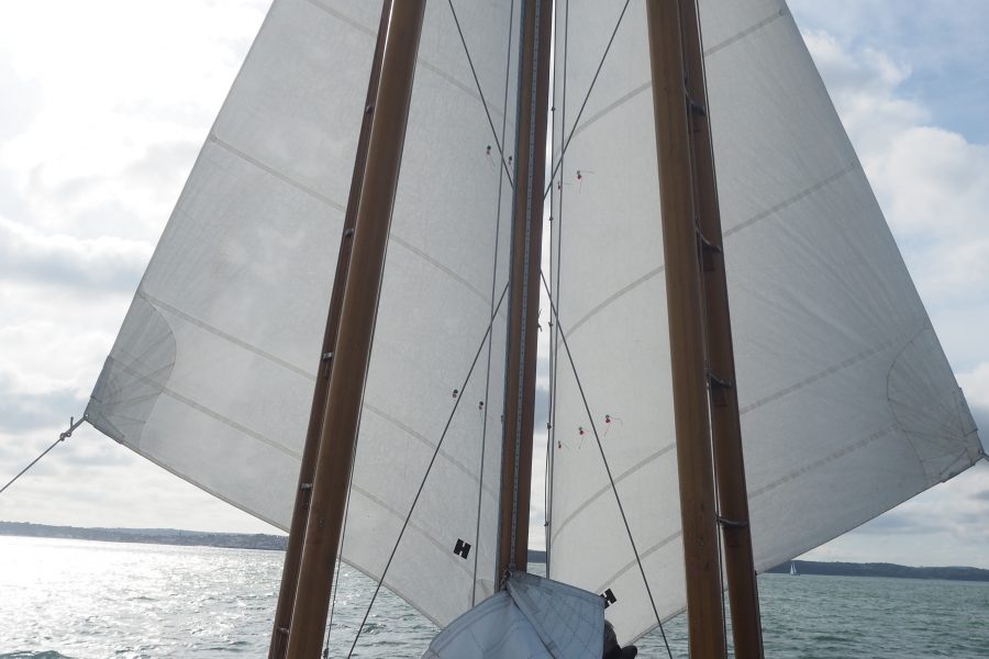 Boleh heading downwind, sporting her signature rig of boomed-out headsails and with a hint of sunshine ahead.